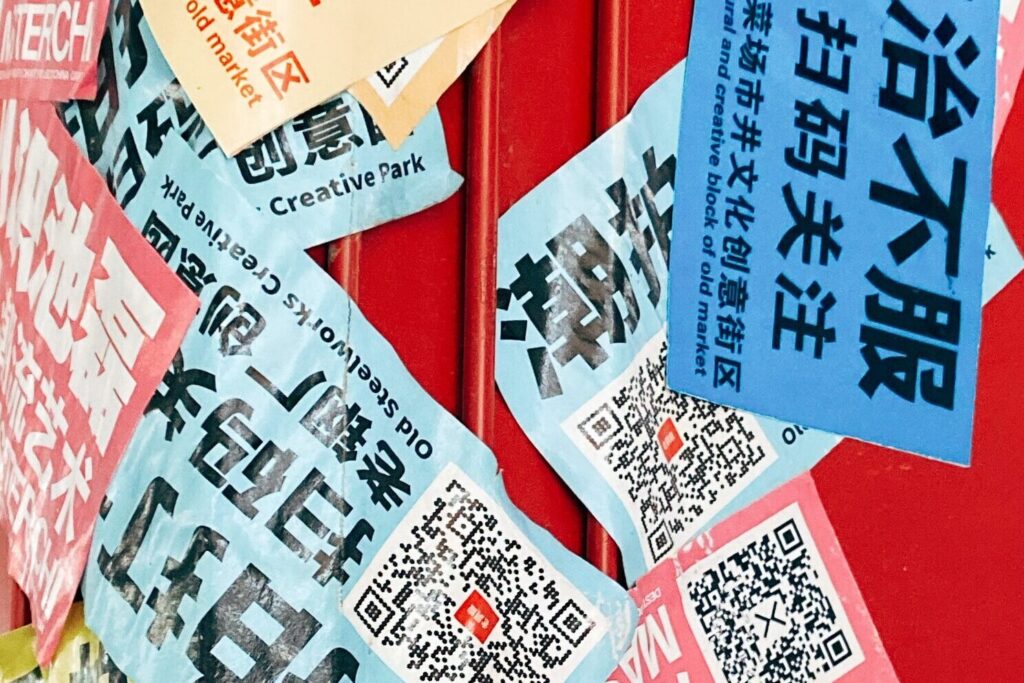 Red mailbox with Chinese QR code stickers.