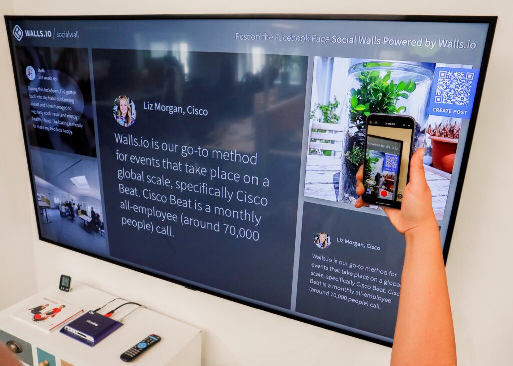 A person utilizes interactive QR codes to enhance customer experience while photographing a tv screen.
