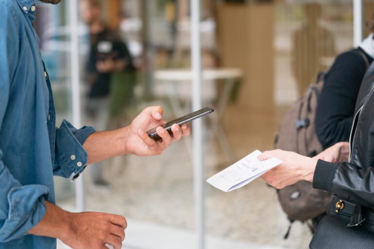 A man is using QR codes for event ticketing while talking to a woman on a cell phone.