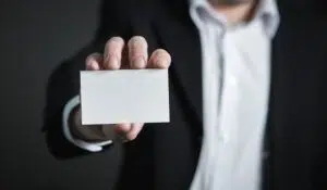 A businessman holding a blank business card for personal branding.