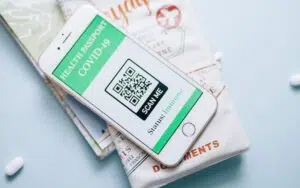 A mobile phone with a QR code displaying emergency information next to pills and a map, ensuring safety.